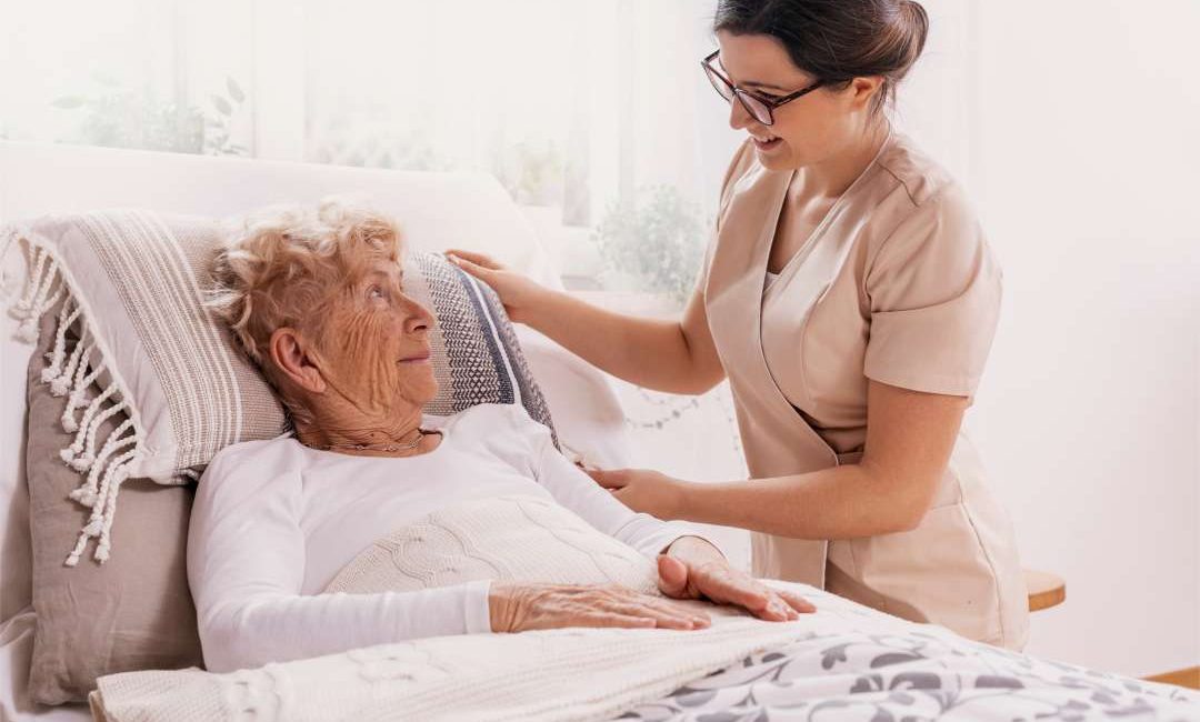 Elderly woman in bed receiving a round the clock care