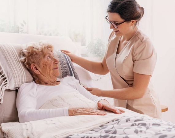 Elderly woman in bed receiving a round the clock care